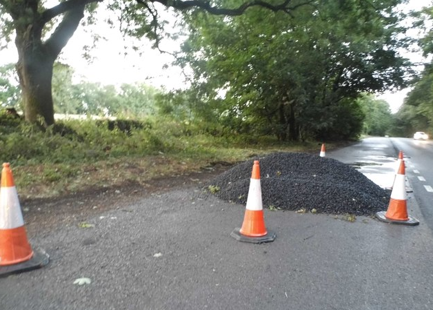 asphalt road lay next to traffic cones